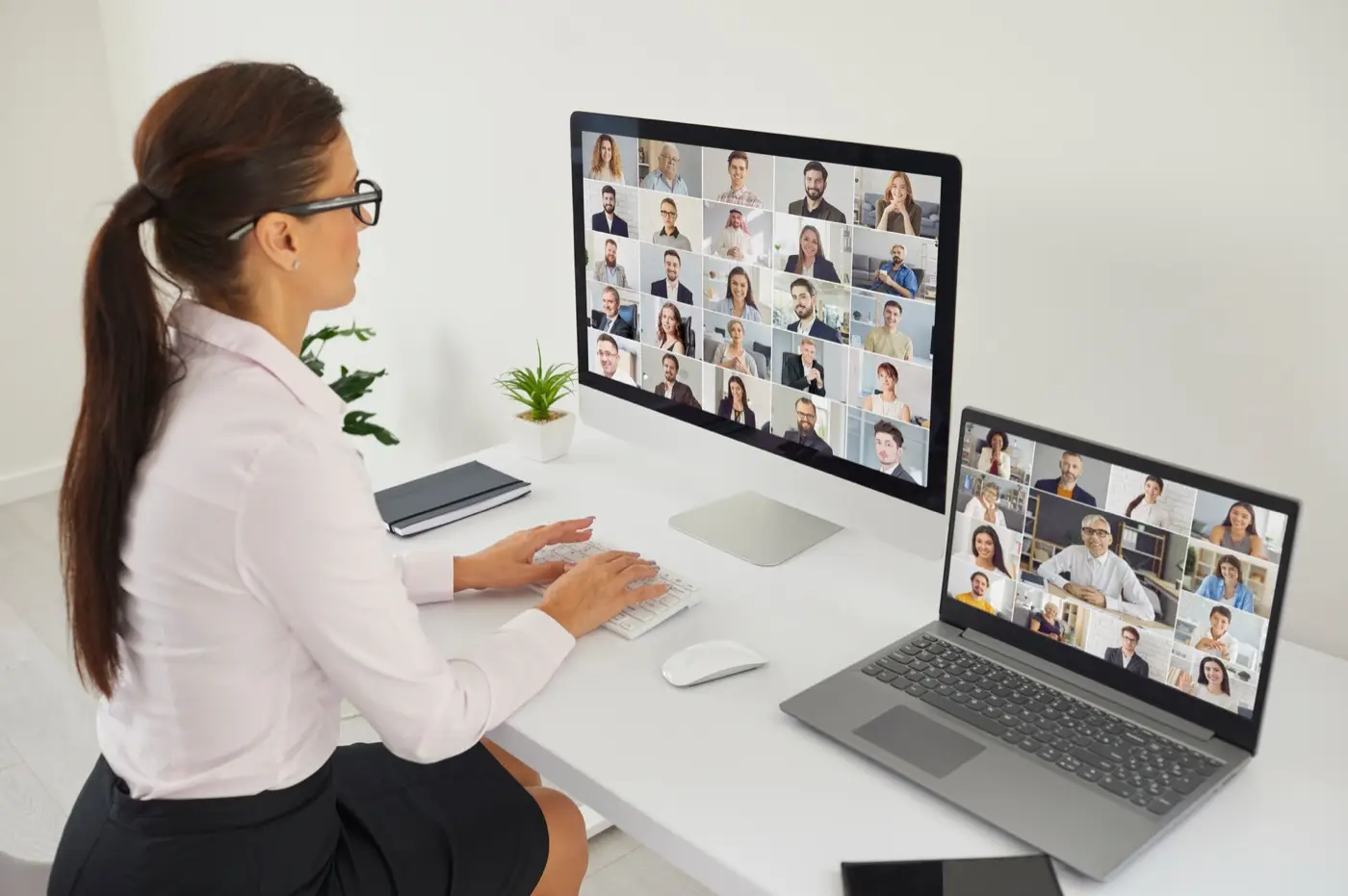 A businesswoman chairing a virtual board meeting across two screens, the way many DIFC structures were governed this year